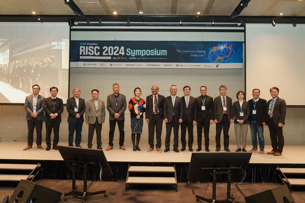 국제 심포지움 현장. 에스티팜 김경진 대표이사(사진 오른쪽에서 7번째)와 주요 연사들이 RISC 2024에서 기념사진을 촬영하고 있다. [사진=에스티팜]