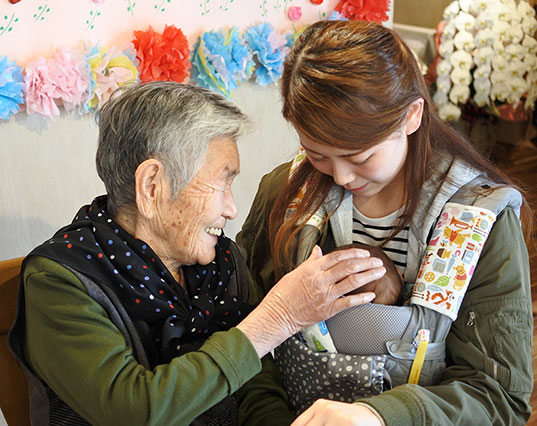 아이를 보고 웃고 있는 아오이케어 입소자. [사진=아오이케어]